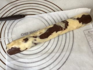 4、双色曲奇,使面团互相混合,揉捏的次数不宜多,多了全部融合在一起花纹就不漂亮了。将捏好的面团整成大的圆柱形放入冰箱冷冻30分钟以上,不要忘了垫油纸或包保鲜膜