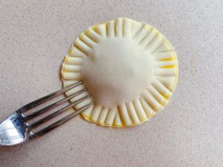 8、香蕉飞饼卷,用勺子压出花形，并将两片饺子皮压实防止香蕉泥流出