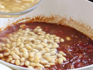 11、茄汁黄豆,黄豆连同煮剩的水一同倒入锅中,大火烧开。