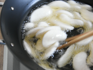 3、年糕秘制小零食，用它开店必定火爆的不得了,用筷子剥离年糕片，防止粘连，炸至年糕香脆