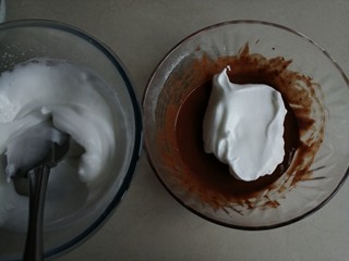 9、可可味小蛋糕卷,用刮刀把1/3打发好的蛋白霜到可可蛋黄糊里，右手拿着刮刀，从底部划J字翻拌，左手逆时针转动打蛋盆