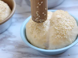 6、烤菠萝鸡肉汉堡,二发完成的面团表面刷上蛋液,用檊面杖粘芝麻于面团上。放入预热180度的烤箱内,20分钟左右,上色均匀即可。上色重了记得加盖锡纸。具体以自家烤箱的脾气调整烤制的温度和时间。