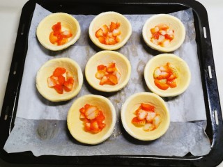 10、草莓蛋挞,蛋挞皮放入烤盘  将草莓放入蛋挞皮里一部分