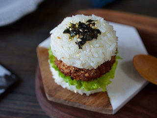 13、米饭汉堡,最后再盖上一个米饭饼，上面撒上海苔碎（事先把海苔撕碎）和熟白芝麻点缀，一个米饭汉堡就完成啦，想做几个随意哈