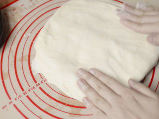 3、绵绵脆巧奶油包,轻轻拍扁,排出大气泡。大致分割成8份,每份重量大约68g。