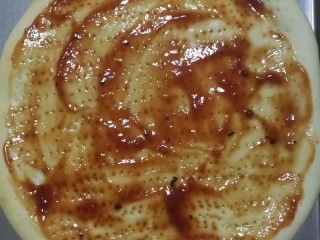 12、鲜虾火腿披萨,烤五分钟之后的披萨饼皮,拿出来上面涂上番茄酱或者披萨酱。