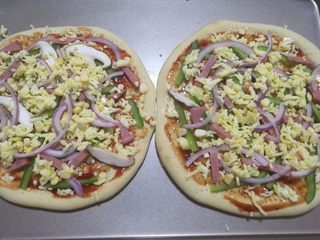 14、鲜虾火腿披萨,再撒上一点点芝士碎,铺上洋葱,火腿,玉米粒等。