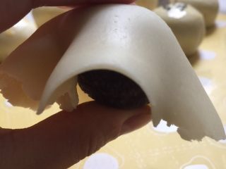 25、没错，高筋粉也能做蛋黄酥,用一只手按着豆沙馅儿，把面片翻转过来。另一只手往下轻轻的捋面片，让面片都垂直，并尽可能的贴着豆沙馅