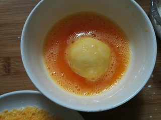 17、圆土豆+爆浆拉丝土豆球,放入鸡蛋液中，让土豆球均匀裹上鸡蛋液。