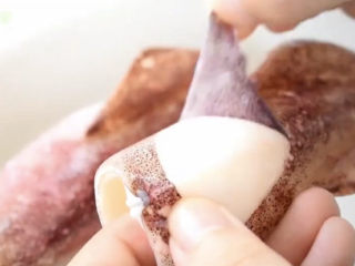 5、黄金鱿鱼圈,趁热剥掉鱿鱼的皮，不剥掉一会一炸也会缩起来，不好看