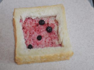 5、苹果花土司盒,把切好的土司框框叠到刚刚涂好果酱的土司片上