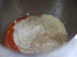 2、胡萝卜热狗面包,做营养美味早餐,厨师机面缸中,放入液体,加入粉类,放入干酵母。预留的水分也暂时不放,黄油不放。