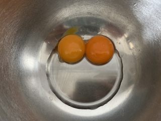 2、桂花蛋糕,鸡蛋的蛋清和蛋黄分离,分别装在干净无水无油的容器内。玉米油加入到蛋黄内,用手动打蛋器搅拌均匀。