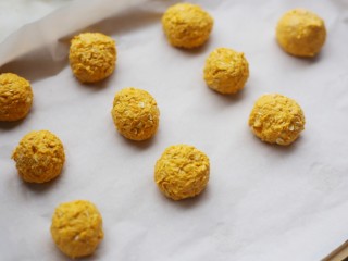 9、南瓜燕麦饼,取适量南瓜泥,搓成小球,放在铺了烘焙纸的烤盘上。