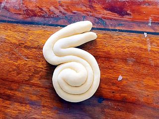 8、松软好吃萌小兔馒头（一次发酵）,然后卷起来，如图所示，整形成兔子的形态！