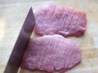 3、香酥黄金炸猪排,用刀背横竖横路剁,记得两边都要剁
