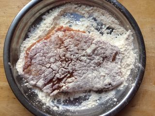 13、香酥黄金炸猪排,取一片腌制好的猪排,均匀地裹上一层面粉,生粉也可以
