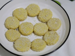 6、软糯香甜的奶香红薯圆饼 一口平底锅就搞定了,将芝麻撒入盘中，做好的小饼外面均匀裹上白芝麻。