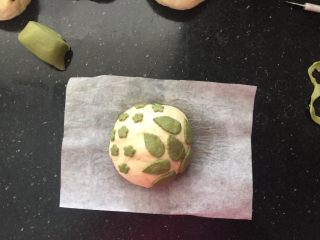 19、抹茶欧克软欧包,揭去多余的面皮，把小花和树叶直接粘在整形后的发酵面团上。