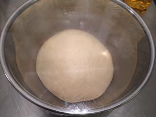 3、绵绵吐司（直接法）,将面团取出，搓圆放入盆内，盖上保鲜膜进行一发（25度－28度）