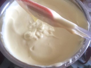 16、黄桃奶油蛋糕卷,1/3的蛋白加入蛋黄糊里面,用橡皮刮刀抄底翻拌均匀。