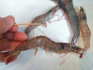 1、避风塘炒虾,明虾从背后剪开，用牙签挑去沙线