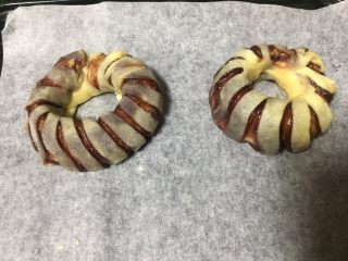 15、最爱豆沙甜圈圈,放入烤盘，利用烤箱再次发酵，为了避免面包胚表皮干硬，烤箱事先预热了45度，并且烤箱底部放入一盘清水