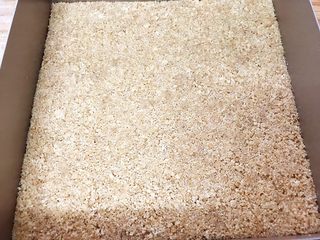 4、原味芝士条,烤盘里铺上油纸倒入饼干末压紧压实，放入冰箱冷藏半个小时