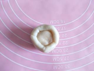 5、酥掉渣的蛋黄酥，月饼季做起来,取一个油皮，包住一个油酥，利用手虎口位置慢慢捏紧，收口向下放置。