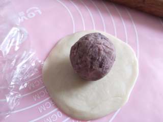 18、酥掉渣的蛋黄酥，月饼季做起来,放入包了蛋黄的豆沙，收口捏紧，放到烤盘上。