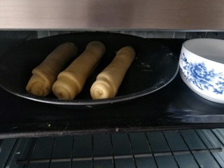 22、毛毛虫面包,三个全部卷好之后放入烤箱进行二次发酵，旁边放一碗热开水，防止水分蒸发过快，表皮变硬，二次发酵约40分钟