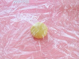 14、菠萝包,案板上铺一层保鲜膜，将酥皮面团放上去，上面再覆盖一层保鲜膜