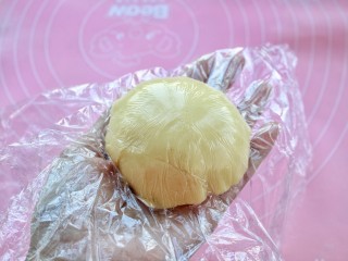 16、菠萝包,揭去上面的一层保鲜膜，把酥皮包裹在面团上，再拿掉上面的保鲜膜