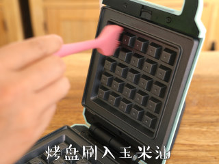 8、【布鲁塞尔松饼】浓浓巧克力风味,早餐机预热至红灯灭，烤盘刷上玉米油，使用挖球勺舀入约65g面糊，盖上上盖，烘烤6分钟，取出置于晾架晾凉