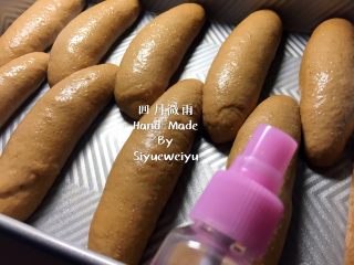 4、全麦杂粮面包,发酵好面包胚，这时预热烤箱200度上下火。发酵好的面包胚表面均匀的喷一层纯净水