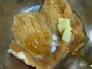 3、自制炸鸡排,下入盐，姜片，料酒抓抹均匀腌制二十分钟
