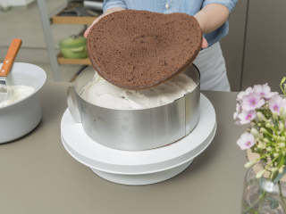 5、黑森林蛋糕,将蛋糕水平地切成均匀的三层。混合樱桃汁和樱桃白兰地。将蛋糕最底层放入盘中,刷上白兰地混合物,再将樱桃馅均匀地抹开,边缘处留白约1厘米。放冰箱冷藏10分钟。将蛋糕环紧贴地围住第一层蛋糕,将生奶油的一半在上面抹开,抹平表面。铺上第二层蛋糕,浸上樱桃白兰地混合物,再覆上剩下的打发奶油并抹开。铺上顶层蛋糕,刷上剩下的樱桃白兰地混合物。放冰箱冷藏至少60分钟。