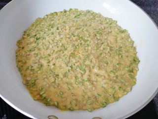 9、蒜苔尖鸡蛋饼,倒入蒜苔尖鸡蛋糊，用铲子摊平。