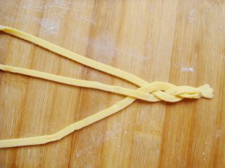 8、水果花篮面包,取三条一端捏紧，编成小辫子。