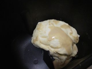 4、酸奶软欧,取出冷藏的面团,抹上融化的酵母;