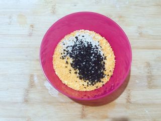 14、万紫千红香蕉紫薯燕麦饼,把准备好的黑白芝麻倒入面包糠的碗里，搅拌均匀备用！