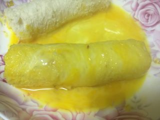 6、黄金吐司卷,将面包卷沾满蛋液。