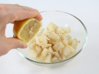 6、香烤鱼米花,挤入几滴新鲜柠檬汁，胡椒粉和柠檬汁可以去除鱼的腥味；拌匀，腌制5分钟左右。