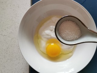 4、酸奶鸡蛋饼,放入10克白糖  打入一个鸡蛋搅拌均匀