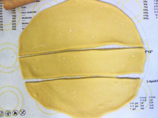 5、沙琪玛,然后将静置好的面团擀成大薄片,越薄越好,擀面时揉面垫上可以撒上适当的淀粉防沾,接着在用刮板切成三等分(此时锅内倒入半锅油量,小火加热)