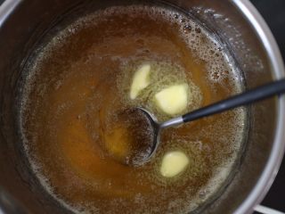12、沙琪玛,熬好的糖浆关火,在放入黄油,用刮刀搅拌至完全融化