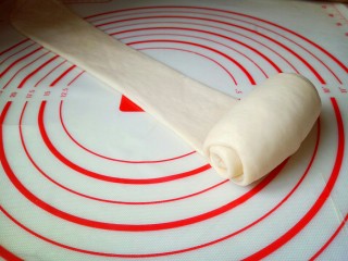 12、原味吐司,取一块面团用擀面杖擀长舌状，再卷起来，从上往下卷，依次做完。