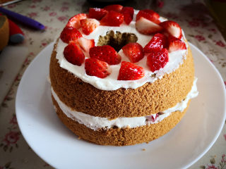 11、冰雪奇缘蛋糕,一层蛋糕片，抹上适量淡奶油，放在合适的草莓粒，再抹一层淡奶油，接着放上第二片蛋糕片，反复操作，至所有的蛋糕片叠在一起，