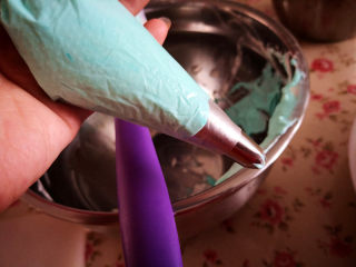 14、冰雪奇缘蛋糕,另取100克淡奶油，加入10克糖，加入适量青色色素打发至硬性泡发，装入裱花袋里，裱花嘴选用5齿的，	