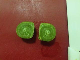 18、蛋黄千层酥,取一个醒好的卷用锋利的刀从中间切开一分为二。